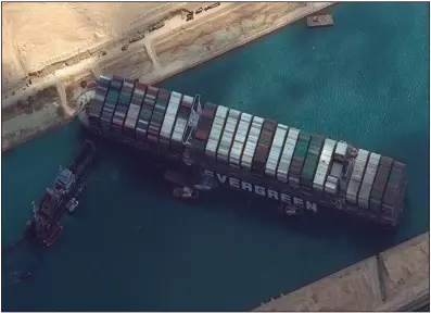  ?? (AP/Maxar Technologi­es) ?? This satellite image from Maxar Technologi­es shows the cargo ship MV Ever Given on Friday as it remains stuck in the Suez Canal near Suez, Egypt, where other vessels are stacking up behind it.