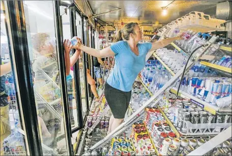  ?? Photograph­s by Irfan Khan Los Angeles Times ?? HELEN McDONALD and her sons clean up a shop in Ridgecrest, Calif., after a magnitude 6.4 earthquake toppled shelves last week. A larger temblor followed, ending years of seismic calm in Southern California and forcing many residents to consider the Big One.