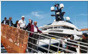  ?? — Bernama ?? Inspection completed: Dr Mahathir waving as he alights from ‘Equanimity’ at Pulau Indah, Port Klang. Coming down the gangway with him is yacht captain Oyastein Senneseth (white shirt).