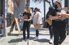  ?? Jessica Christian / The Chronicle ?? Katherine Flores, Sehar Fatima, Amira Amana and Nicole Menegus, from left, walk doortodoor down Mission Street with vaccine informatio­n, as part of a partnershi­p between San Francisco’s Department of Public Health and UCSF.