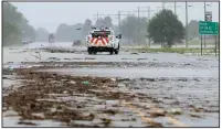  ?? Arkansas Democrat-Gazette/STEPHEN B. THORNTON ?? A Burlington Northern Santa Fe Railway truck moves Wednesday through water along a debris-strewn stretch of U.S. 63 east of Portia in Lawrence County. The highway was closed at U.S. 67 near the railroad’s flooded tracks.