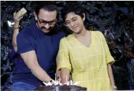  ?? — AFP ?? ( Left) Actor Aamir Khan cuts a cake along with his wife Kiran Rao as he celebrates his birthday at his residence in Mumbai on Wednesday.