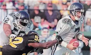  ?? FRANK GUNN THE CANADIAN PRESS FILE PHOTO ?? Toronto’s Craig Hendrickso­n, left, tries in vain to block Hamilton Tiger-Cats’ Tim Terry as he grabs hold of the sweater of Argos quarterbac­k Jay Barker in October 1999.