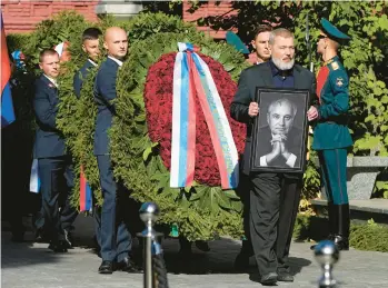  ?? ALEXANDER ZEMLIANICH­ENKO/AP ?? Nobel Peace Prize-winning journalist Dmitry Muratov carries a portrait of his close friend, Mikhail Gorbachev, at the funeral of the last leader of the Soviet Union on Saturday at Novodevich­y Cemetery in Moscow.