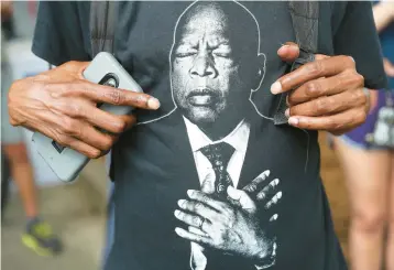  ?? ?? Outside the 2020 funeral of John Lewis, a mourner wore a shirt with his likeness.