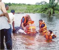  ??  ?? ANGGOTA bomba mengeluark­an mangsa lemas di Paya Rawa, Besut.