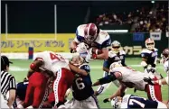  ??  ?? AP PHOTO BY ITSUO INOUYE In this 1992 file photo, East’s Kevin Turner, of Alabama, dives over the top for a touchdown in the fourth quarter of the Japan Bowl, the American collegiate all-star football game, at the Tokyo Dome.