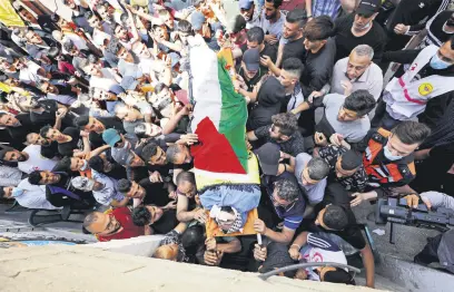  ??  ?? Mourners carry the body of a Palestinia­n man killed by Israeli forces, in the Israeli-occupied West Bank, Palestine, May 12, 2021.