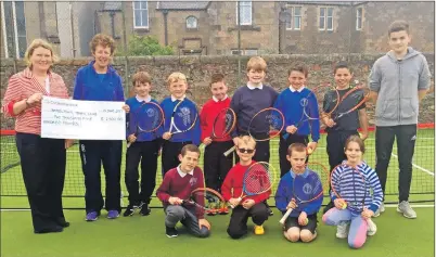  ??  ?? Springbank regional sales manager and keen tennis player Melanie Stanger hands the cheque to Campbeltow­n tennis club secretary Catherine Dobbie surrounded by primary pupils from Castlehill, Dalintober and Drumlemble.