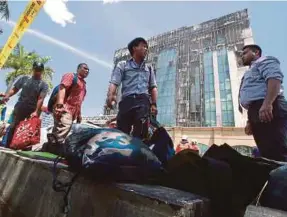  ??  ?? Employees Provident Fund staff with their belongings outside the EPF building in Jalan Gasing.