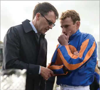  ??  ?? Aidan O’Brien in conversati­on with jockey Ryan Moore after winning the Irish St. Leger last month.