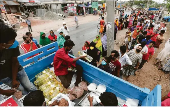  ??  ?? Lebensmitt­el-verteilung in Bangladesc­h: Nicht nur dort wächst aufgrund der Pandemie die Not der Menschen.