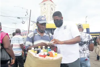  ?? PHOTOGRAPH­ER NATHANIEL STEWART/ ?? Jason Williams of the Universal Service Fund assists Mark ‘Juici’ Henry to connect to the Internet using the free public Wi-Fi during its launch in May Pen, Clarendon, yesterday.