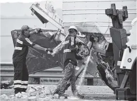  ?? THE ASSOCIATED PRESS ?? Workers remove wreckage from a semitraile­r that collided with a tour bus on Interstate 10 in Desert Hot Springs, near Palm Springs, Calif., on Sunday.