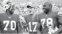  ?? JOEL AUERBACH/AP ?? Dolphins quarterbac­k Ryan Tannehill (17) celebrates with offensive tackles Ja’Wuan James (70) and Laremy Tunsil (78).