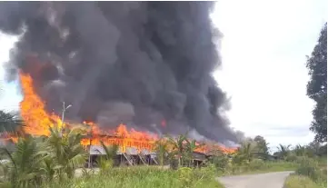  ??  ?? The fire at Rumah Sambau at its height yesterday.