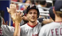  ?? ERIC ESPADA / GETTY IMAGES ?? Shortstop Trea Turner of the Washington Nationals (congratula­ted by teammates after scoring Friday in a game against the Marlins) sent the offending tweets in 2011-12.