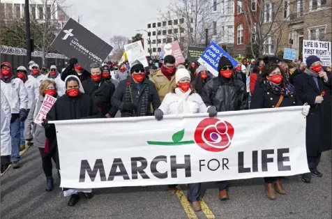  ?? Susan Walsh/Associated Press ?? Anti-abortion advocates walk through Washington on Friday for the 48th annual March for Life, which was held mostly virtually. COVID-19 rules and the inaugurati­on of President Joe Biden, who supports abortion rights, gave the activities a somber mood.