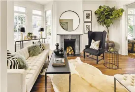  ??  ?? Above: The living room features a wood-burning fireplace, pocket doors and wide moldings. Below: The eat-in kitchen revolves around a marble island with waterfall edges.