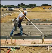  ??  ?? Carlos Patio works the fresh concrete at the North 40 mixed-use developmen­t.