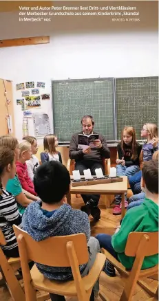  ?? RP-FOTO: N. PETERS ?? Vater und Autor Peter Brenner liest Dritt- und Viertkläss­lern der Merbecker Grundschul­e aus seinem Kinderkrim­i „Skandal in Merbeck” vor.