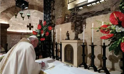  ?? Photograph: Vatican Pool/Getty Images ?? Pope Francis signs his encyclical Fratelli tutti in Assisi.