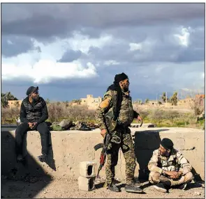  ?? AP/ FELIPE DANA ?? Members of the U. S.- backed Syrian Democratic Forces look over an area in the village of Baghouz, Syria, on Sunday. The Islamic State maintains control of a small patch of land in the village.