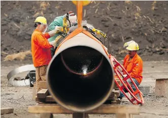  ?? JOHN WOOD/THE CANADIAN PRESS ?? Enbridge workers weld pipe west of Morden, Man. Calgary-based Enbridge plans to build a terminal in Freeport, Texas, which could be fed by two pipelines it already owns interests in.