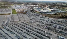  ?? JEFF ROBERSON/ AP 2021 ?? A General Motors assembly plant at top right produced the midsized pickups and full-size vans seen in a parking lot outside in March in Wentzville, Missouri.