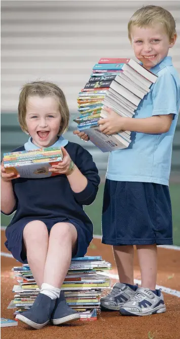  ?? Picture: PETER RISTEVSKI ?? READ ALL ABOUT IT: Whittingto­n Primary School prep students Charli Sanderson and Rylie Brideson check out some of the books donated by the Dymocks Children’s Charities.