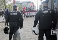  ?? ?? Police look on as demonstrat­ors hold a banner which reads “we shall not let this pass” on April 16 outside of the National Conservati­sm conference in Brussels.