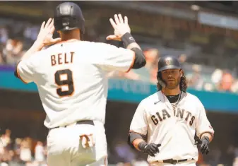  ?? Ezra Shaw / Getty Images ?? Brandon Belt greets Brandon Crawford after the shortstop hit a threerun homer in the second.