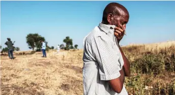  ?? — AFP file photo ?? A man reacts as he stands near a ditch in the outskirts of Mai Kadra, Ethiopia, that is filled with more than 20 bodies of victims that were allegedly killed in a massacre on Nov 9.