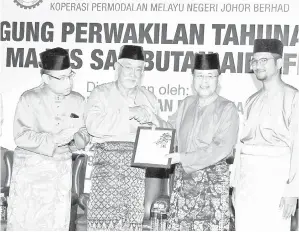  ??  ?? MENTERI Besar Johor Datuk Osman Sapian (dua, kanan) menyerahka­n sijil Kurniaan Tanah (Notis 5A) kepada Pengerusi KPMNJ, Prof. Madya Datuk Mohamad Ali Hasan (dua kiri) selepas merasmikan Majlis Mesyuarat Agung Perwakilan Koperasi Permodalan Melayu...