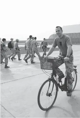  ?? SEAN KILPATRICK / THE CANADIAN PRESS ?? A German soldier rides past Canadian troops as they make their way to a briefing at a UN base in Gao, Mali, on Monday. German peacekeepe­rs are ending their medical evacuation missions there on Saturday.