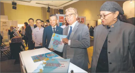  ?? — Photo by Chimon Upon ?? Abang Johari (centre), flanked by Deputy Economy Minister Datuk Hanifah Taib and Regional Corridor Developmen­t Authority chief executive officer Datu Ismawi Ismuni, is pictured with the 12th Malaysia Plan booklet at the Malaysia SDGs Summit 2023 Sarawak Region.