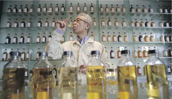  ?? KOJI UEDA/THE ASSOCIATED PRESS FILES ?? Chief blender Shinji Fukuyo demonstrat­es how he examines whisky at the Suntory distillery in Yamazaki.