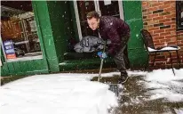  ?? Kristopher Radder/Associated Press ?? Mikey Reynolds shovels the sidewalk in front of a restaurant in Vermont on Saturday during a snowstorm.