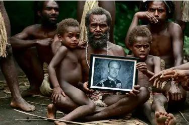  ??  ?? LEFT: Chief Albi, with members of his family, holds a portrait of Prince Philip. BELOW: The photo of Philip with his ‘nal nal’.