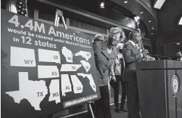  ?? J. Scott Applewhite / Associated Press ?? Sens. Tammy Baldwin, D-Wis., and Raphael Warnock, D-Ga., announce plans Thursday to fix the Medicaid gap in a number of states.