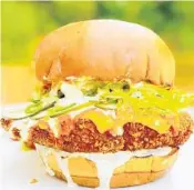  ?? CRACKED BY CHEF ADRIANNE ?? Cracked by Chef Adrianne’s Spicy Chicken Sandwich is topped with spicy American cheese, Buffalo sauce, ranch, homemade pickles, jalapeños, lettuce and onions on a Brioche bun.