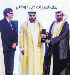  ?? Ahmed Ramzan/Gulf News ?? Banking on it Shaikh Maktoum presenting the award to Hesham Al Qasimi, Vice Chairman- Emirates NBD, as Shayne Nelson, Group CEO of Emirates NBD, looks on.