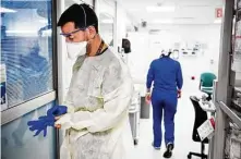  ?? Scott Mcintyre / New York Times ?? Dr. Jheison Girlado applies personal protective equipment before checking on a patient with COVID-19 on July 23 at Jackson Memorial Hospital in Miami.