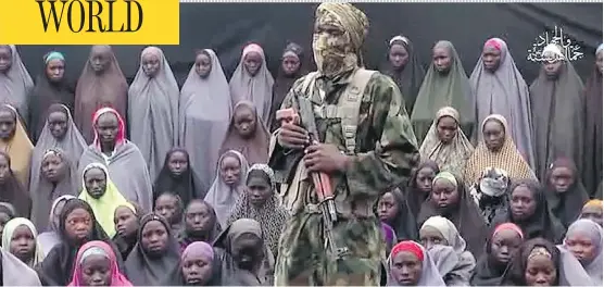  ?? AFP PHOTO / BOKO HARAM ?? A video purportedl­y released by the Nigerian Islamic group Boko Haram allegedly shows one of the group’s fighters standing in front of 50 girls who were kidnapped in a mass abduction from the town of Chibok in April 2014. The fighter demanded the...