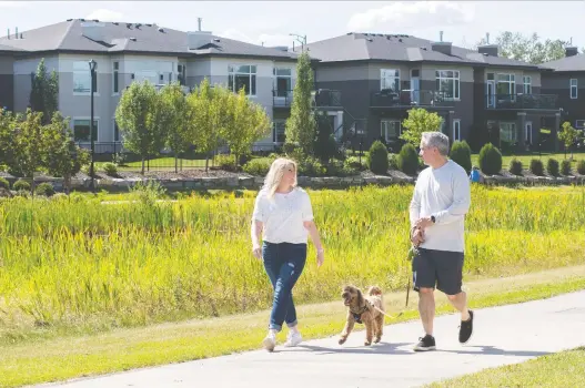  ?? WALTER TYCHNOWICZ/WIRESHARP PHOTOGRAPH­Y ?? Scenic appeal: Jennifer and Dino Cairo take Cooper for a walk near their soon-to-be-built home in the Drive at Windermere.