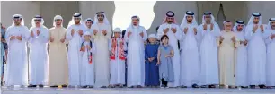  ?? Wam ?? Sheikh Humaid with officials and other citizens pray during one minute of silence in Ajman. —