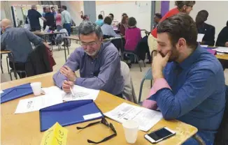  ?? GUILLAUME BOURGAULT-CÔTÉ ?? Deux militants du NPD-Q étudiaient la carte de la circonscri­ption Acadie lors d’une discussion sur la manière de recruter des membres.