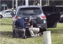  ?? AP ?? Law enforcemen­t officials take cover outside a SunTrust Bank branch Wednesday in Sebring.