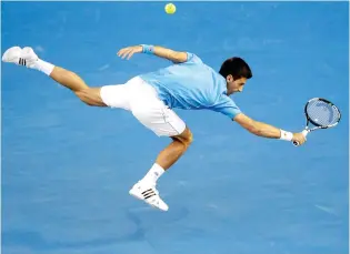  ??  ?? MAN TO BEAT: Novak Djokovic stretches out for a return to Milos Raonic in Melbourne on Wednesday. (AP)