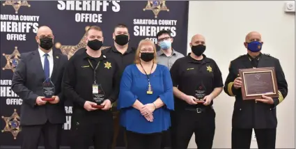  ?? PHOTO PROVIDED ?? Left to right: Saratoga County Sheriff’s Office Director of Emergency Communicat­ions Steven Gordon, Desk Officer Thomas Lundquist, Michael Melucci, telecommun­icator Cheri Melucci, Jake Melucci, Desk Sergeant Kurt Haas and Saratoga County Sheriff Michael Zurlo gather for an awards ceremony on Tuesday at the Saratoga County Sheriff’s Office in Ballston Spa. Gordon, Lundquist and Haas all received Life Saving awards for their role in the reversal of a cardiac arrest.